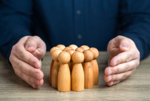 a-man-protects-human-figures-with-his-hands-2023-12-05-03-06-09-utc