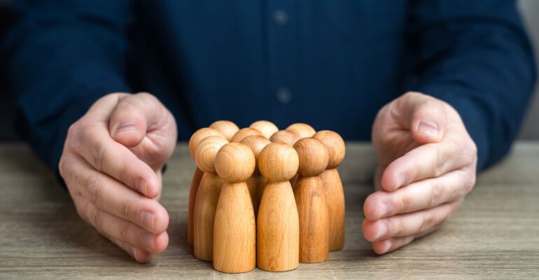 a-man-protects-human-figures-with-his-hands-2023-12-05-03-06-09-utc