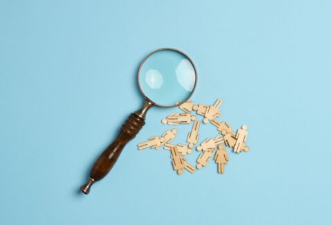 wooden-men-and-a-magnifying-glass-on-a-blue-backgr-2023-11-27-04-54-49-utc